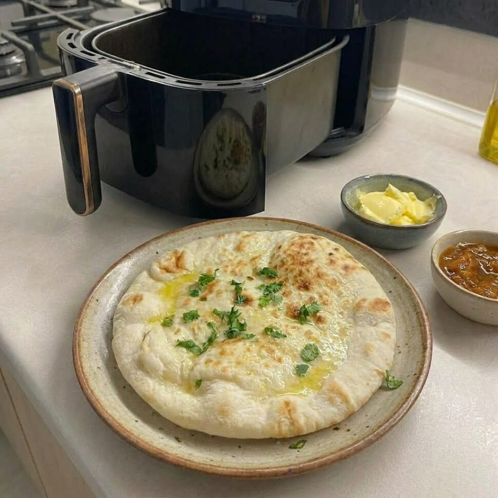 Stack of soft golden flatbreads brushed with melted butter and sprinkled with fresh parsley