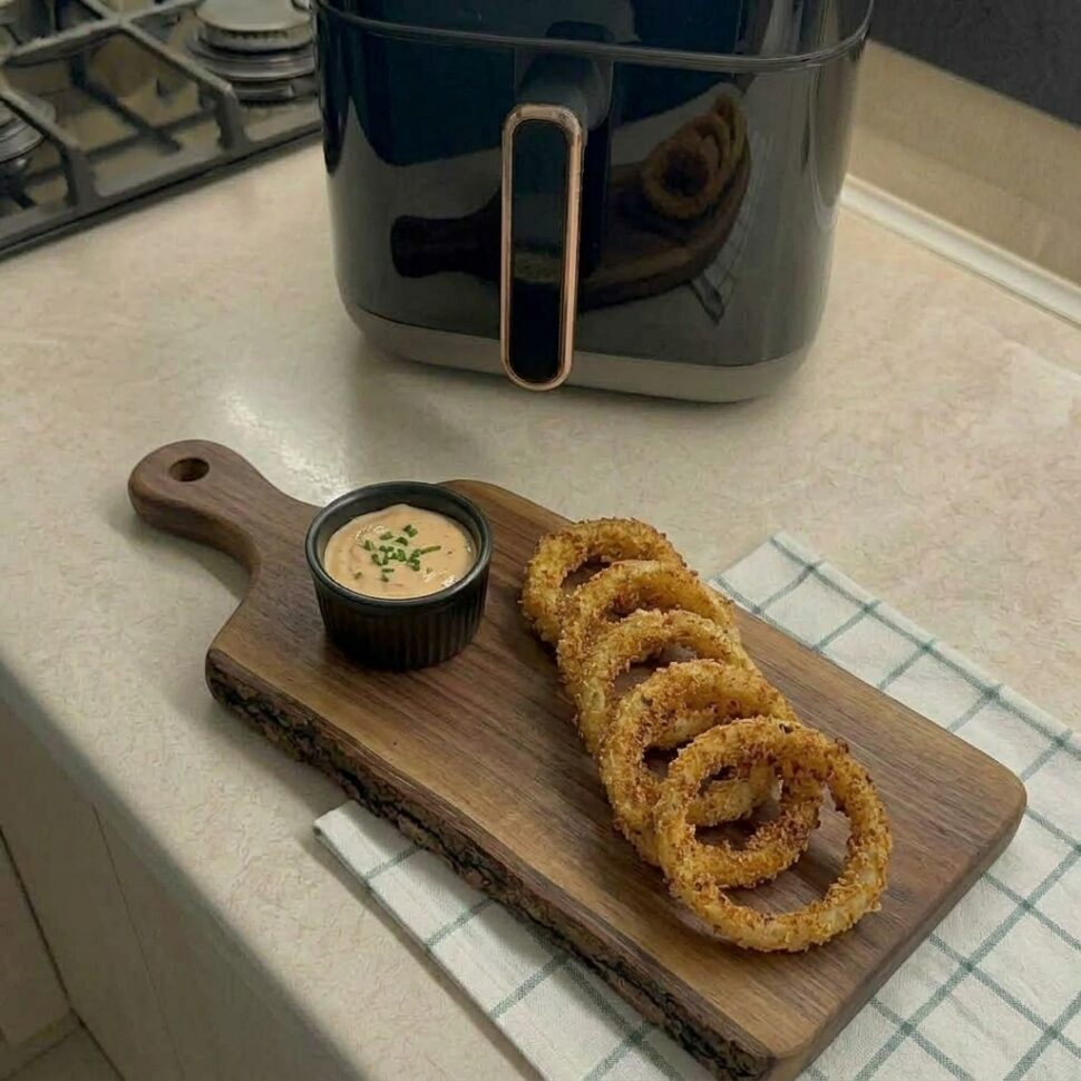 Fresh batch of air fryer onion rings piled high with deep golden color and crisp edges