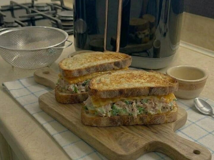 Tuna melt sandwiches cooking in air fryer until bread is golden and cheese melted