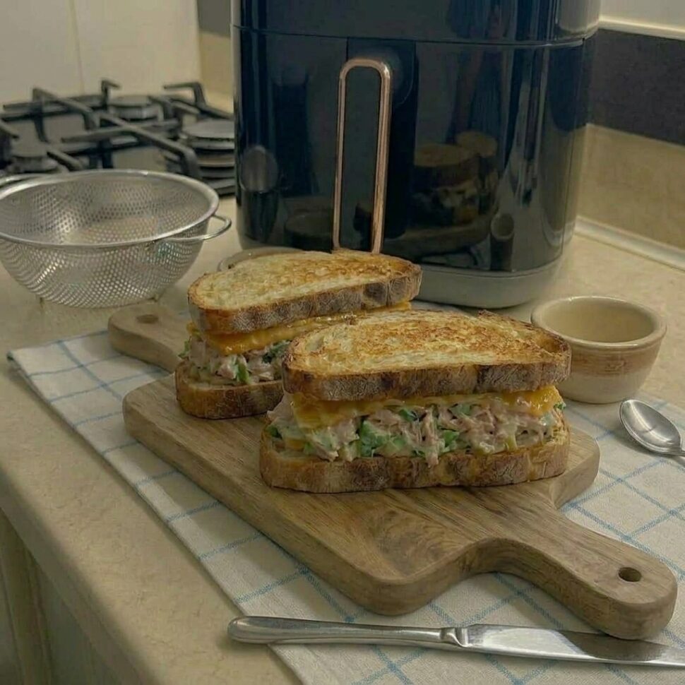 Tuna melt sandwiches cooking in air fryer until bread is golden and cheese melted