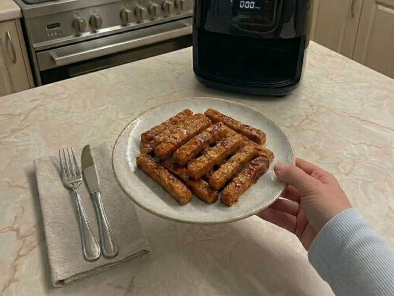 Air fryer basket being shaken halfway through cooking to evenly crisp carrot fries