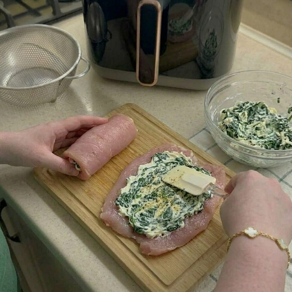 Golden stuffed chicken rolls sliced open showing creamy spinach cheese filling inside