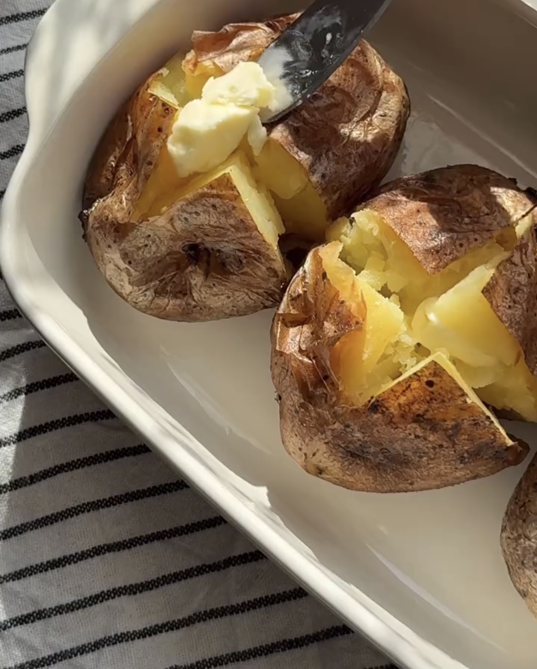 chicken stuffed baked potatoes with fork holes on a baking sheet