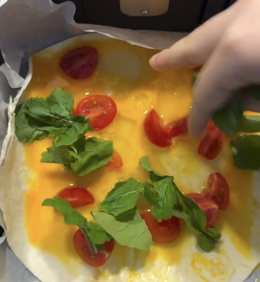 chopped tomatoes added on egg tortilla before cooking
