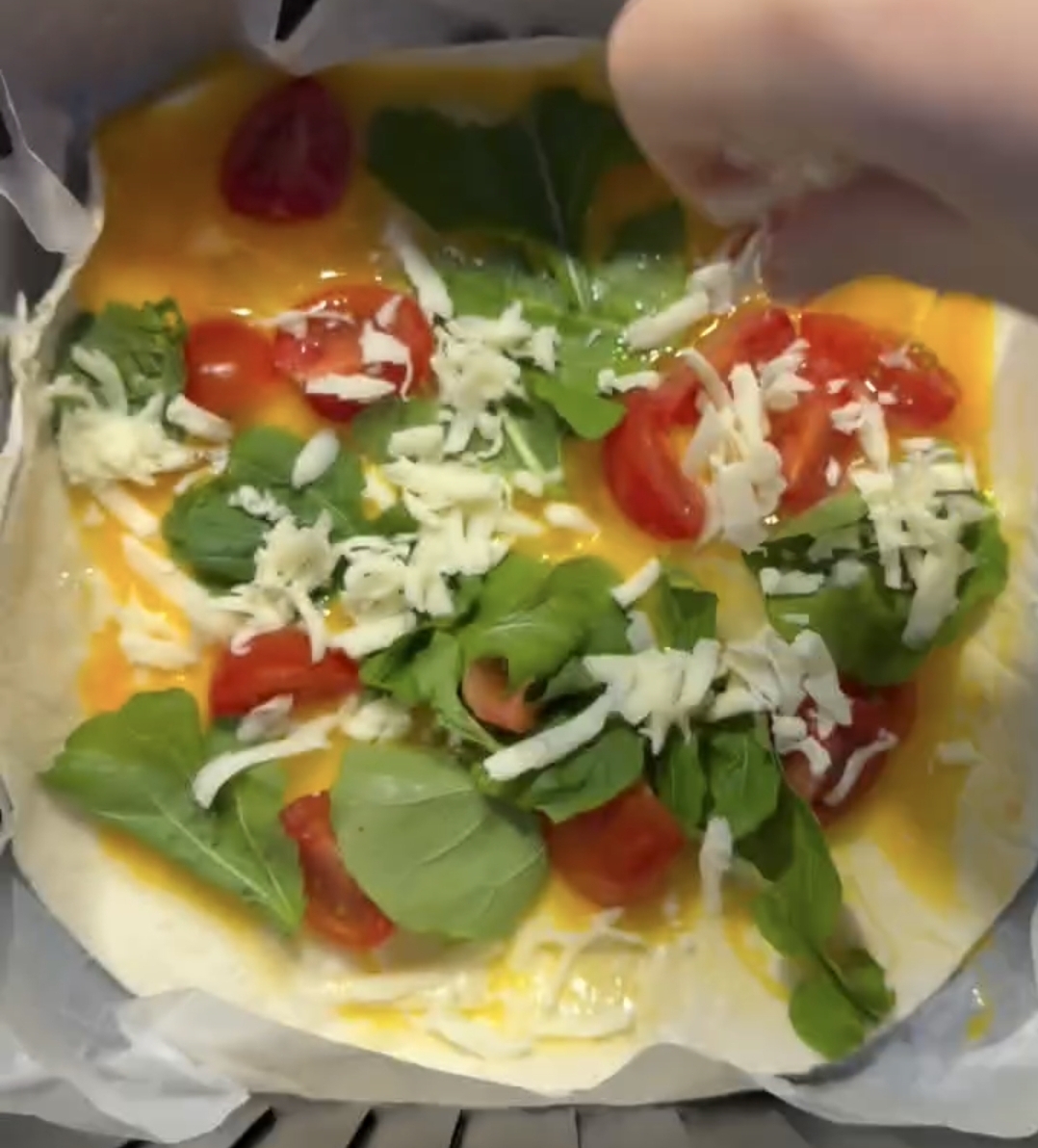 shredded cheese added on top of tortilla omelette filling