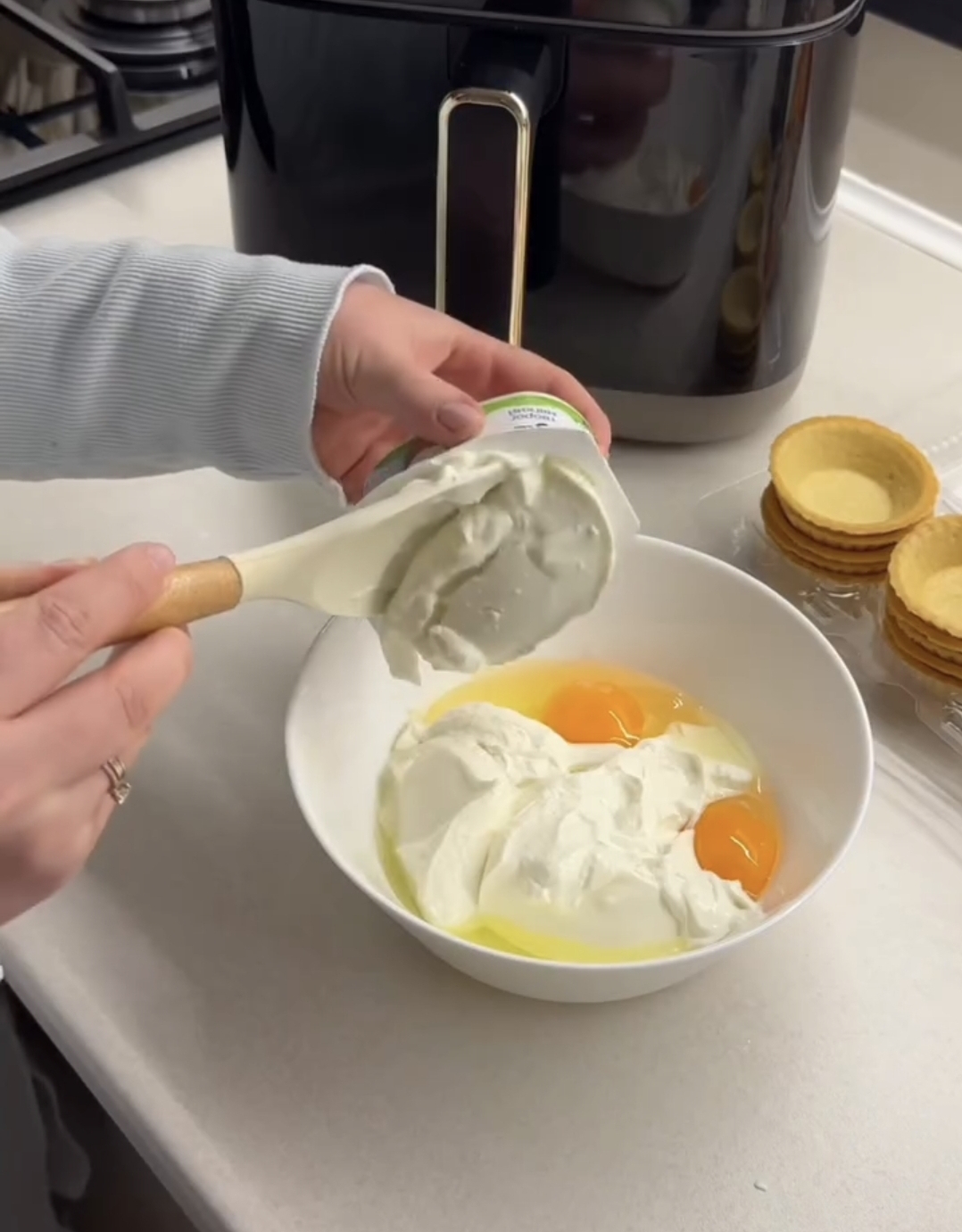 air fryer raspberry casserole eggs being added to the white mixing bowl