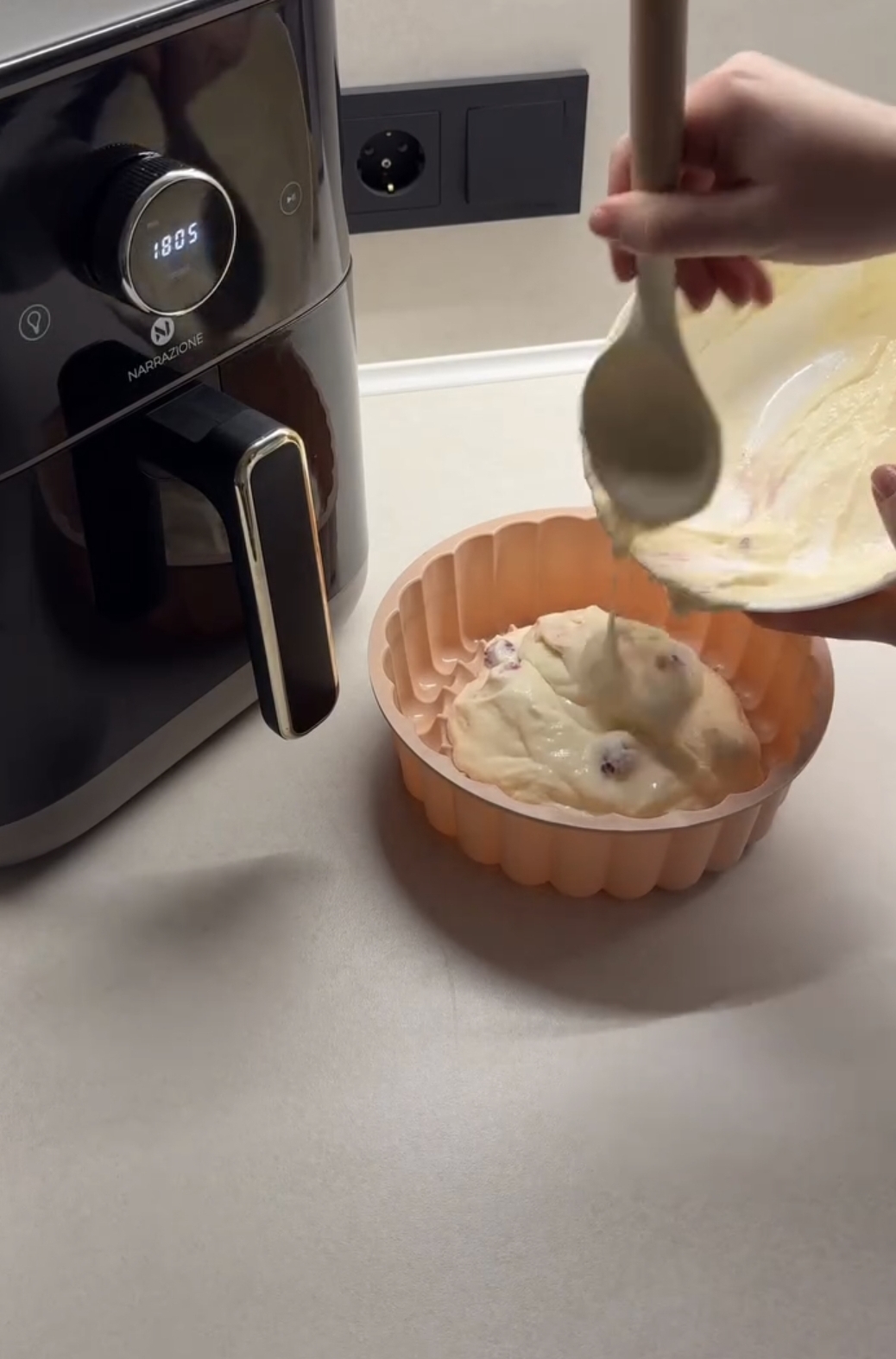 air fryer raspberry casserole being transferred into a pink silicone dish