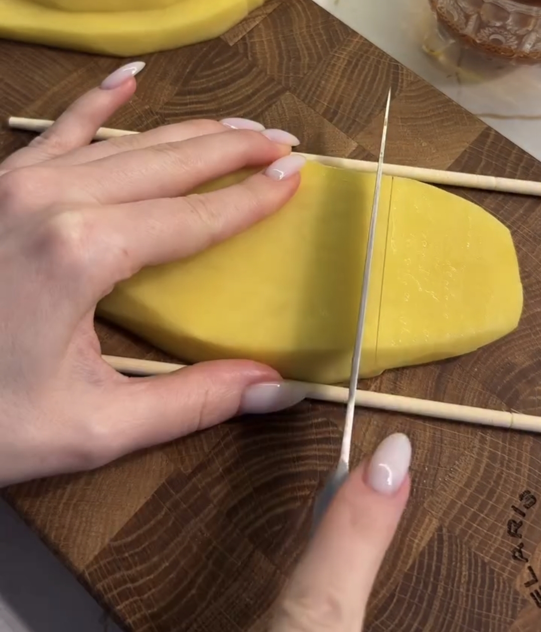 air fryer accordion potatoes being sliced vertically with the knife stopping at the sticks