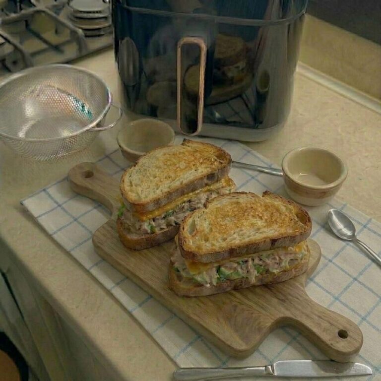 Close-up of tuna melt showing gooey melted cheddar and creamy tuna filling inside