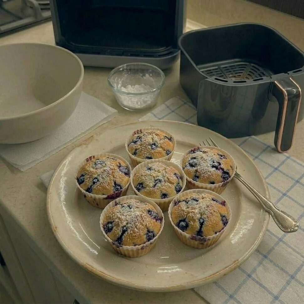Blueberry muffin split open showing steaming soft crumb and juicy berries inside