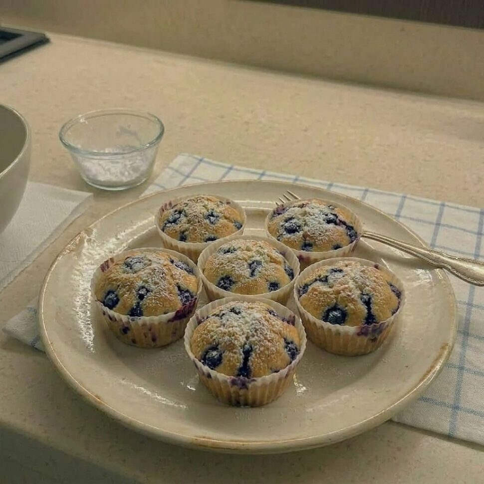 Batch of air fryer blueberry muffins with golden tops and bakery style rise