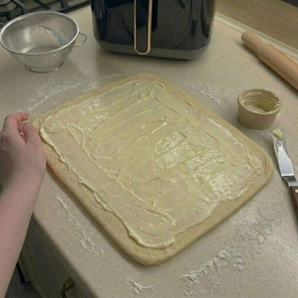 Dough rolled into rectangle and spread with butter cinnamon and brown sugar