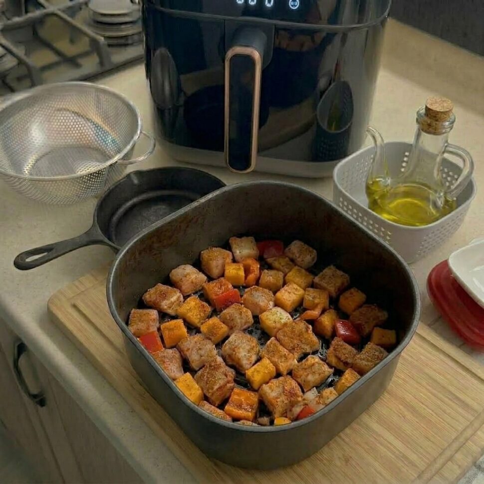 Turkey meatballs arranged in air fryer basket cooking until golden and cooked through